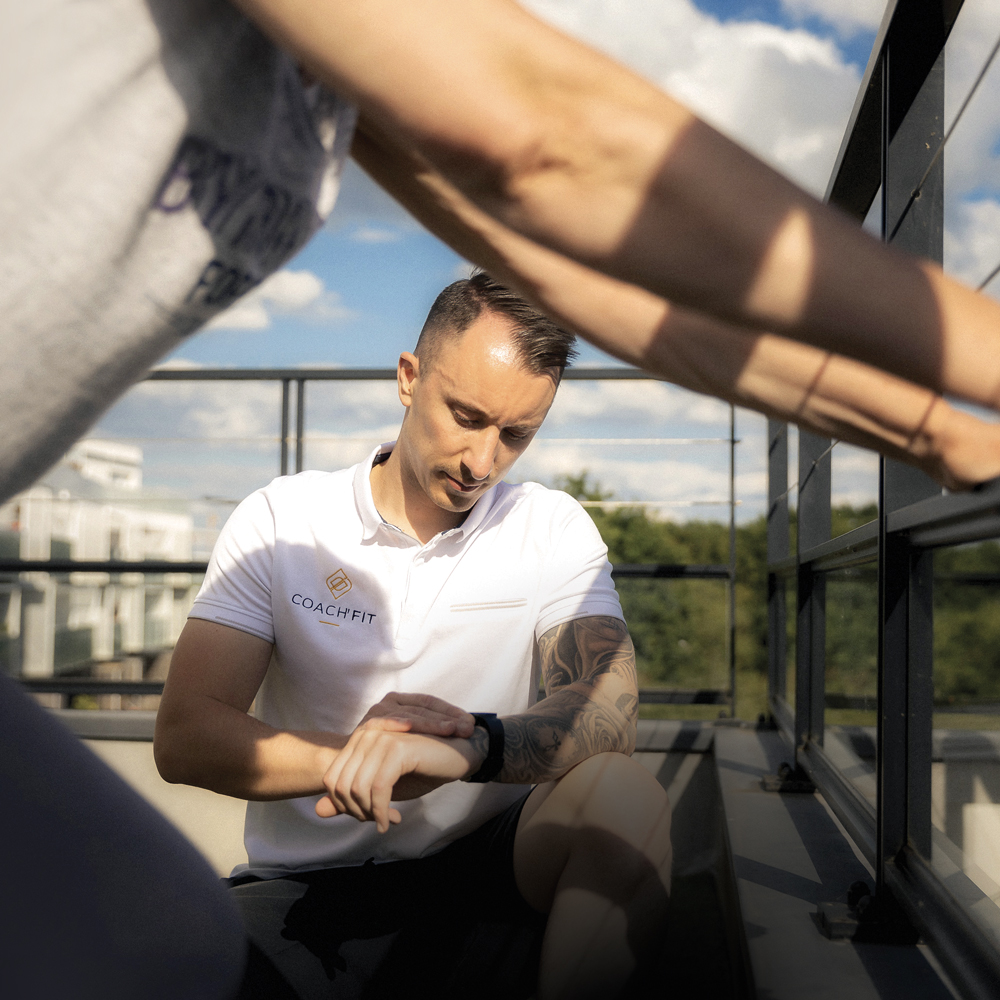 Aurélien qui regarde son chronomètre en pleine séance de coaching sportif à domicile.